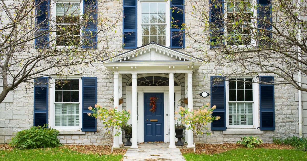 A blue front door, casing, and entry surround on an older home.