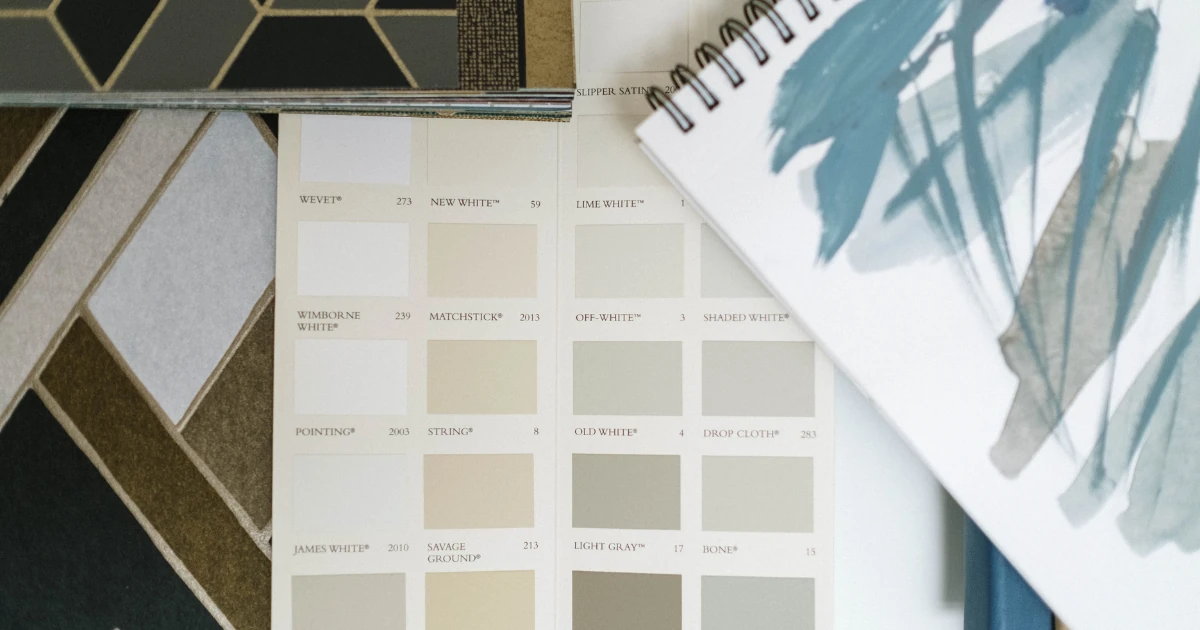 Neutral paint color cards arranged beside tile samples and a painted color study