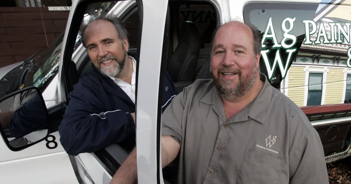 Arthur G. Williams and George P. Williams beside an A.G. Williams company van.