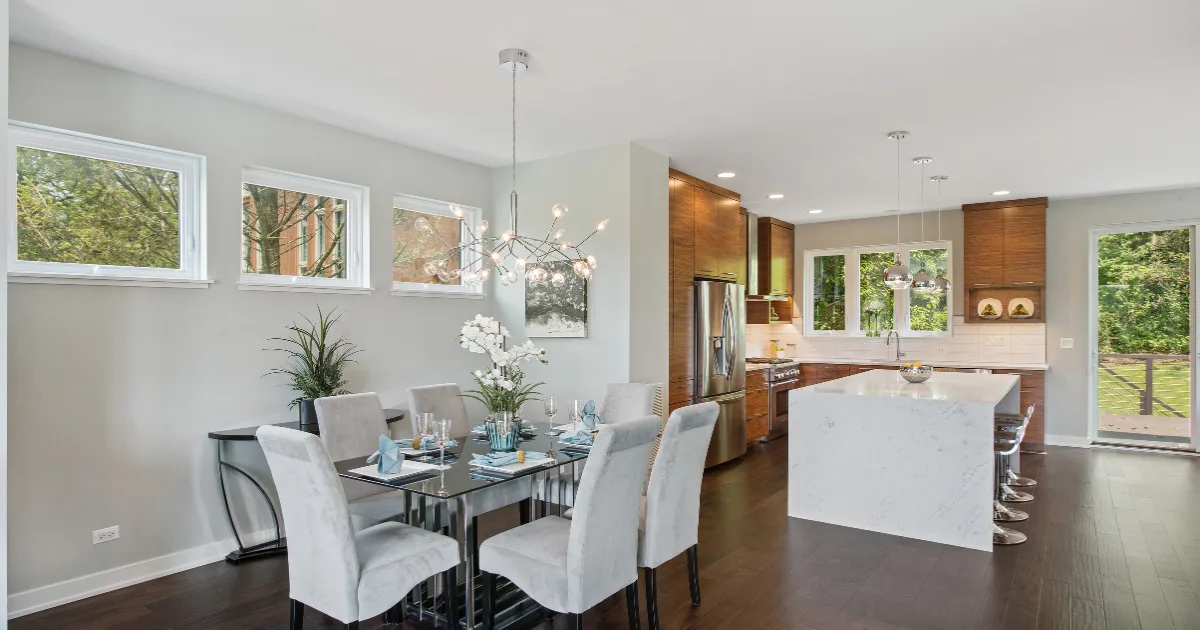 Open dining and kitchen areas linked by pale walls and dark wood cabinetry.