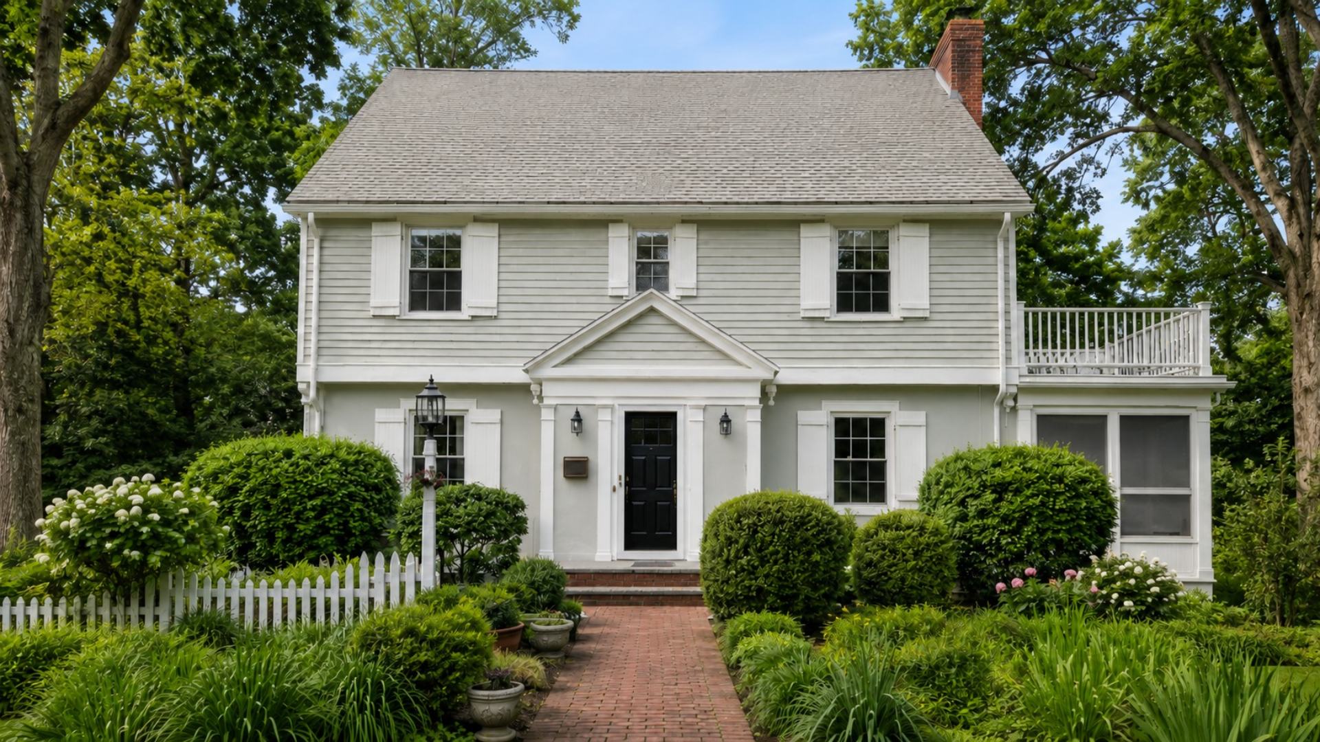 White home exterior with a glossy black front door for the A.G. Williams summer front door upgrade special.