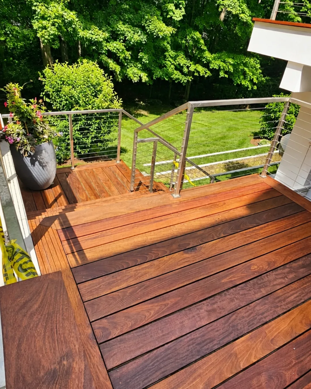 Stained wood deck and stairs with stainless-steel cable railings in Greenwich.